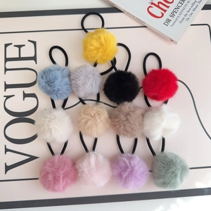 Flat lay of thirteen colorful plush hair ties arranged neatly on a fashion book background