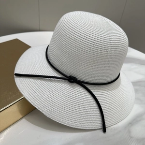Détail d'un chapeau de soleil blanc avec texture tressée et ruban noir élégant