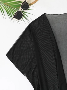 Detail of black mesh cover-up fabric with beach props for a summer vacation vibe