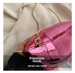 Close-up of golden metal lobster clasp and snake chain on rose pink mirror crossbody bag