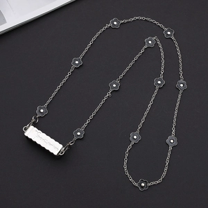 Detail of silver chain phone lanyard with black clover charms and rectangular clip