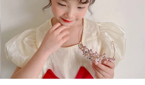 Detail of pink crystal tiara headband for girls on a golden frame for princess costumes