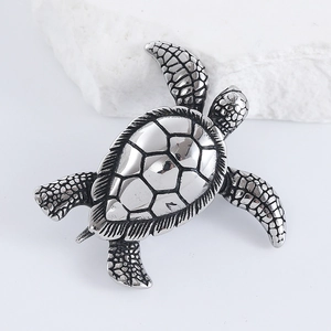 Macro detail of silver sea turtle pendant featuring intricate hexagonal shell patterns