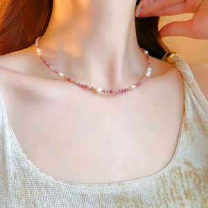 Close-up of elegant pink rhodochrosite beads and freshwater pearls on a gold-toned necklace
