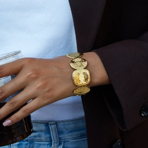 Detail view of 18K gold stainless steel hammered cuff bracelet on model's wrist