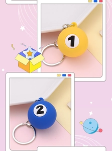 Macro detail of billiard ball keychain charms in yellow No. 1 and blue No. 2 styles