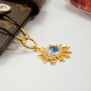 Golden sun evil eye pendant necklace with blue crystal and zircons on black cord