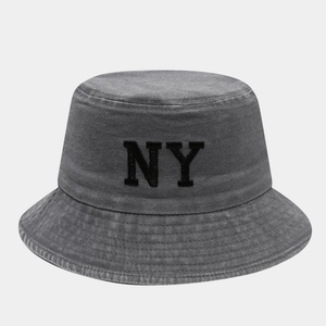 Detail of NY embroidery and vintage washed texture on gray cotton bucket hat