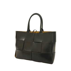 Handwoven black leather tote bag with wide checkers and tan lining on white background