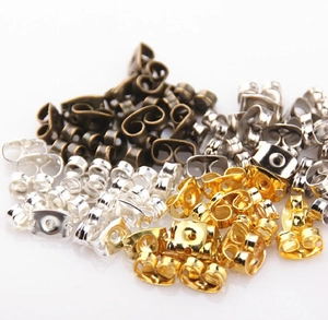 Macro shot of assorted butterfly clutch earring backs in gold, silver, and bronze finish