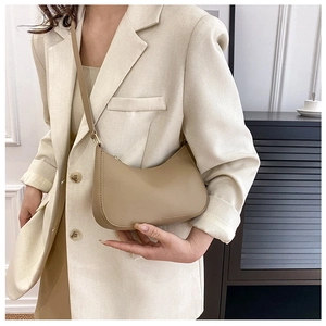 Detailed view of beige crescent hobo bag showing fine stitching and matte leather texture