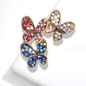 Macro view of vintage gold butterfly brooches set with red, blue and aurora crystals