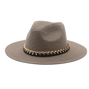 Detailed macro view of brown straw panama hat with gold chain and black leather band