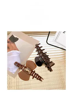 Close-up of two large acetate claw clips in dark coffee and caramel brown colors