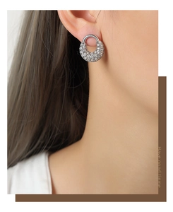 Détail de boucles d'oreilles créoles en U argentées avec zircons micro-pave