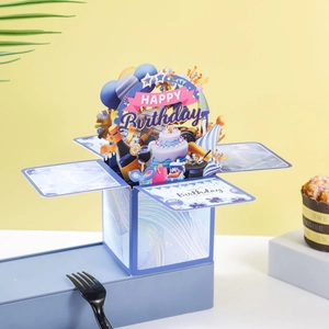 Detailed view of blue and yellow 3D Happy Birthday pop-up card box with paper cake