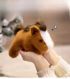 Macro detail of a soft plush guinea pig toy held in hands with warm festive background
