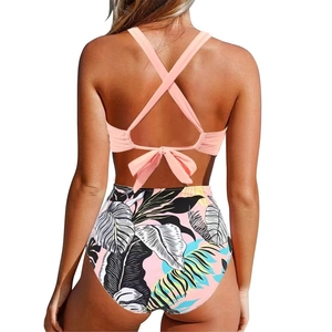 Back view of pink halter swimsuit featuring lace-up straps and tropical leaf print