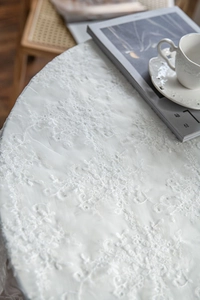 Detailed macro view of white lace tablecloth with elegant floral embroidery patterns