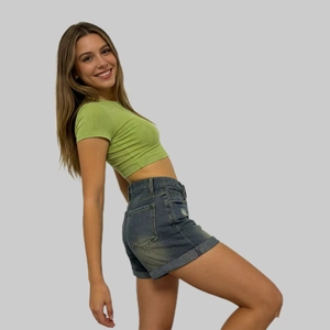 Vista laterale di pantaloncini di jeans a vita alta e crop top a coste verde da donna