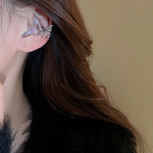 Close-up of a silver butterfly ear cuff with sparkling zircons worn by a model