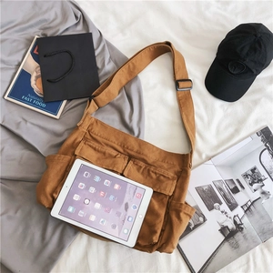 Brown canvas messenger bag for men and women showing large capacity and tablet storage