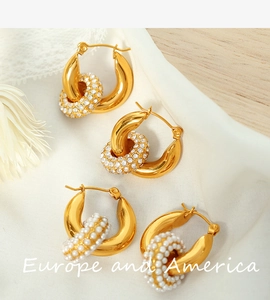Macro detail of gold-plated hoop earrings with micro-paved crystal and pearl charms