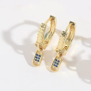 Close-up of golden zipper pull earrings with pave blue zircon stones on white background