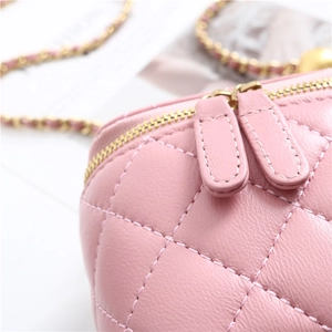 Detail of pink quilted leather texture and gold chain strap on a designer handbag