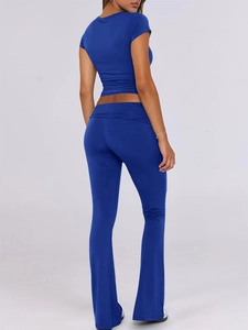 Women's blue two-piece set featuring a short sleeve crop top and flared pants from behind