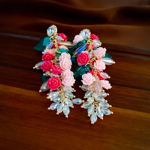 Detail of sweet floral earrings with pink acrylic roses and crystal tassel hangings