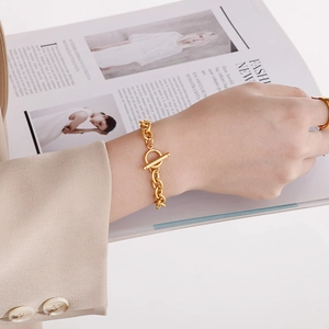 Gold OT clasp thick chain bracelet and matching ring set worn on hand with minimalist style