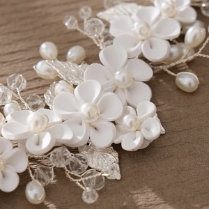 Macro detail of bridal headband with ceramic flowers, white pearls and silver leaves