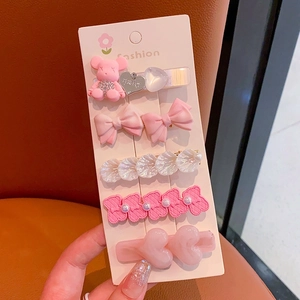 Close-up of pink rhinestone pearl hair clip set featuring bow and bear designs
