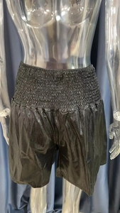 Detail of high waisted black metallic shiny shorts with elastic waistband on a mannequin
