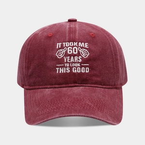 Macro detail of 60th birthday embroidery on a washed burgundy cotton baseball cap