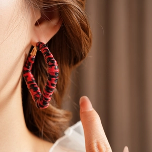 Macro detail of leopard print leather hoop earring on model with vintage aesthetic