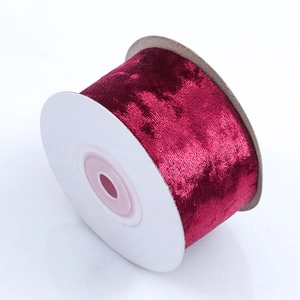 Close-up of premium burgundy velvet ribbon roll for gift wrapping and DIY crafts
