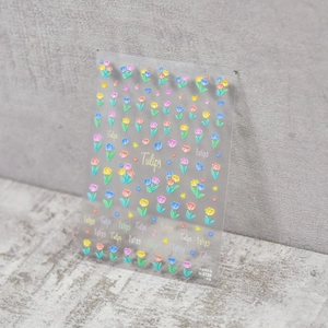 Detailed macro view of 3D embossed tulip nail art stickers with vibrant floral textures