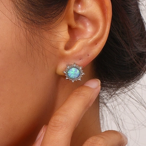 Macro view of sunburst stud earring with opal center and white zircon stones