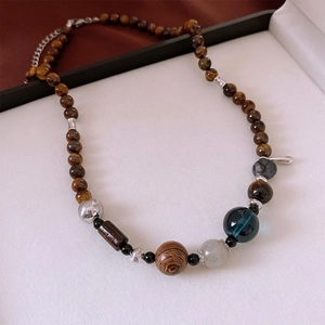 Detailed view of Tiger Eye and wood beaded necklace displayed in a premium jewelry box