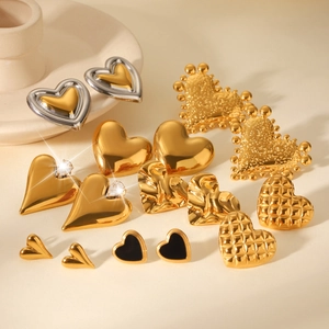 Detail view of various gold heart stud earrings featuring smooth, textured and crystal styles