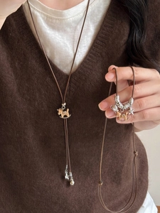 Vue détaillée du pendentif cheval en bois rétro sur collier en cordon marron et argent