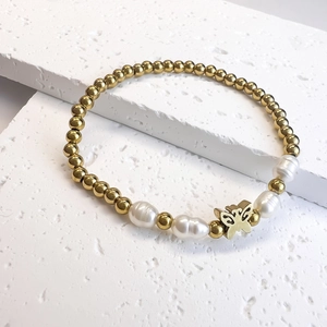 Detail of beaded bracelet with golden beads, freshwater pearls and butterfly charm