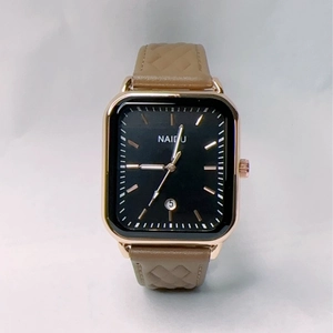 Macro shot of square quartz watch with black dial, gold case, and brown leather strap