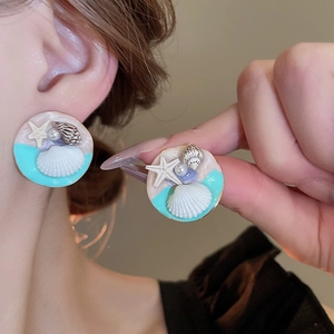 Detail of vintage French gold-plated floral earrings with pearls and starfish