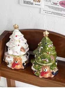 Detail of ceramic Christmas tree storage jars with teddy bear and gold star decorations
