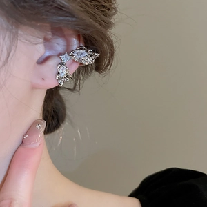 Detailed view of silver zircon ear cuff featuring an irregular streamlined metal design