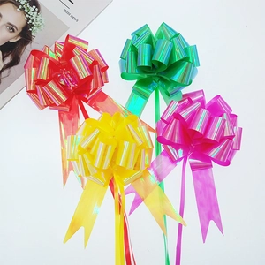 Close-up of holographic pull bows in red, green, yellow and purple for gift wrapping