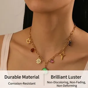 Close-up of gold chain necklace with green enamel disc, sun and star pendants on a model